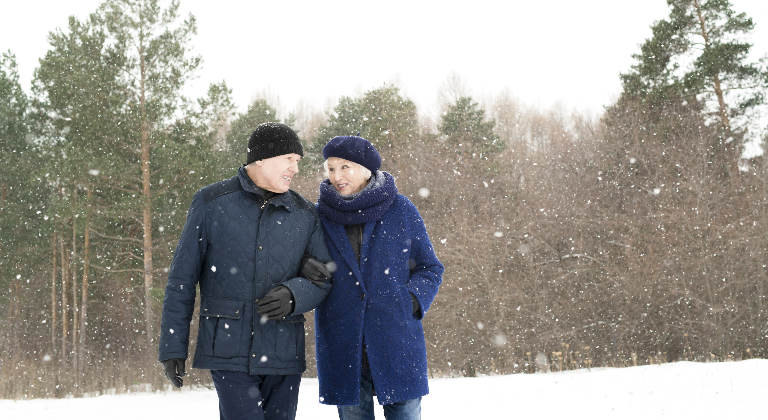 happy_senior_couple_snow_walking